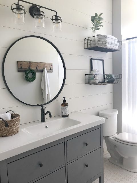 a bathroom with a toilet, sink and mirror on the wall next to a window