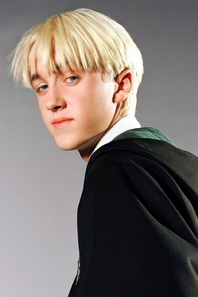 a young man with blonde hair wearing a black jacket