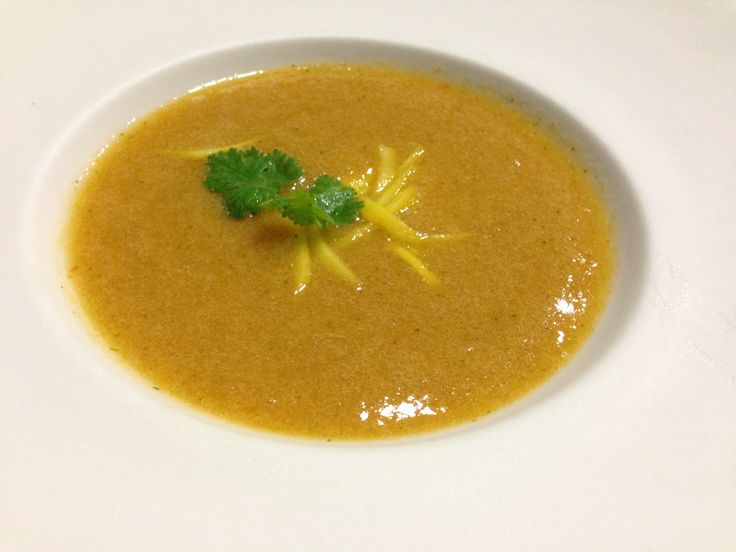 a white bowl filled with soup and garnished with cilantro on top