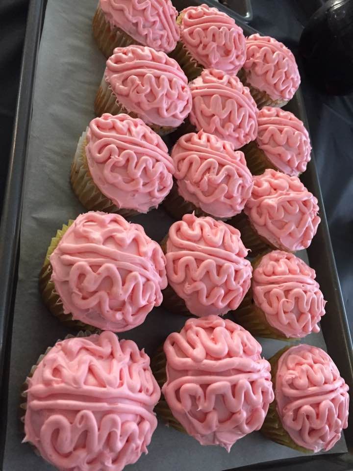 cupcakes with pink frosting are arranged on a tray