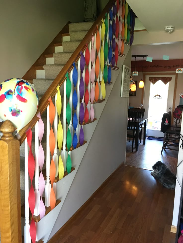 the stairs are decorated with multicolored paper streamers and balloons on each handrail