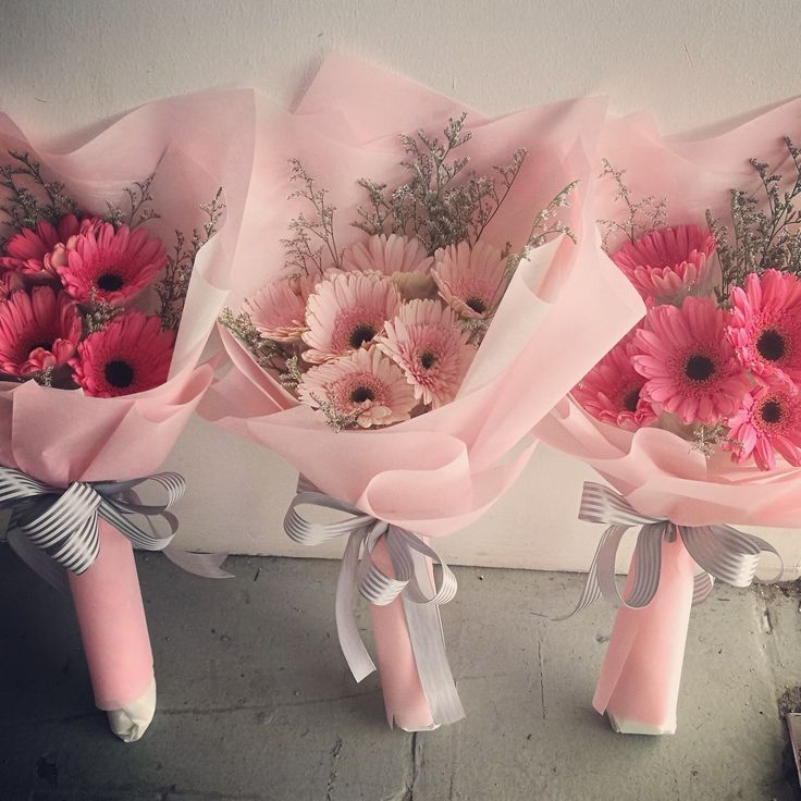 three bouquets of pink flowers are tied together