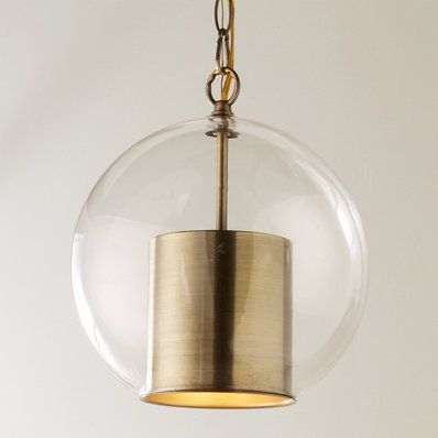 a clear glass ball hanging from a brass colored chandelier with a gold chain