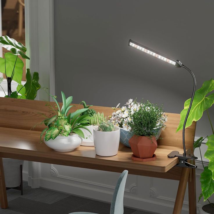 a wooden table topped with potted plants next to a light on top of it