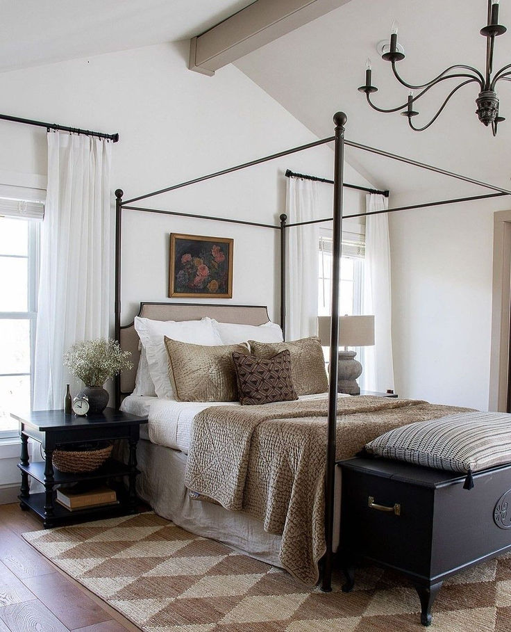 a bedroom with a four post bed and white walls