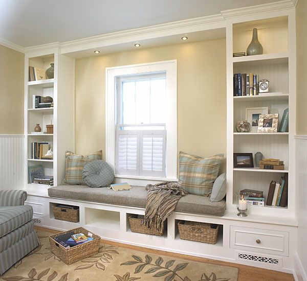 a living room filled with lots of furniture and bookshelves next to a window