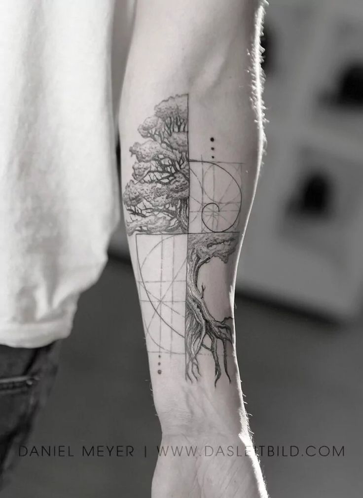 a man's arm with a tree and compass tattoo on the left inner forearm