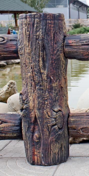 a close up of a wooden fence with water and rocks in the backgroud