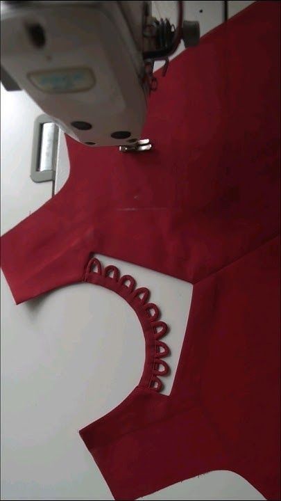 the sewing machine is next to a red shirt with scalloped details on it