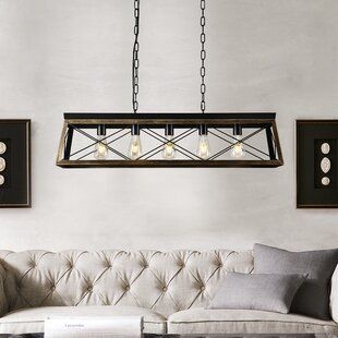 a living room with a couch, table and chandelier hanging from the ceiling