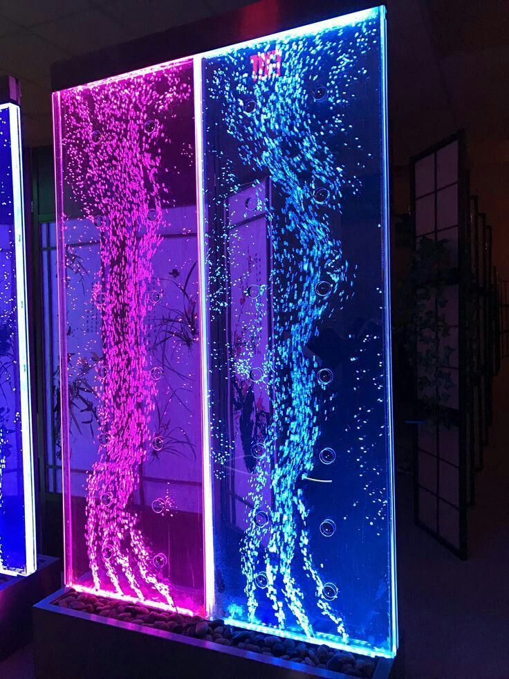 two different colored glass panels with water and plants on them in a dark room next to each other