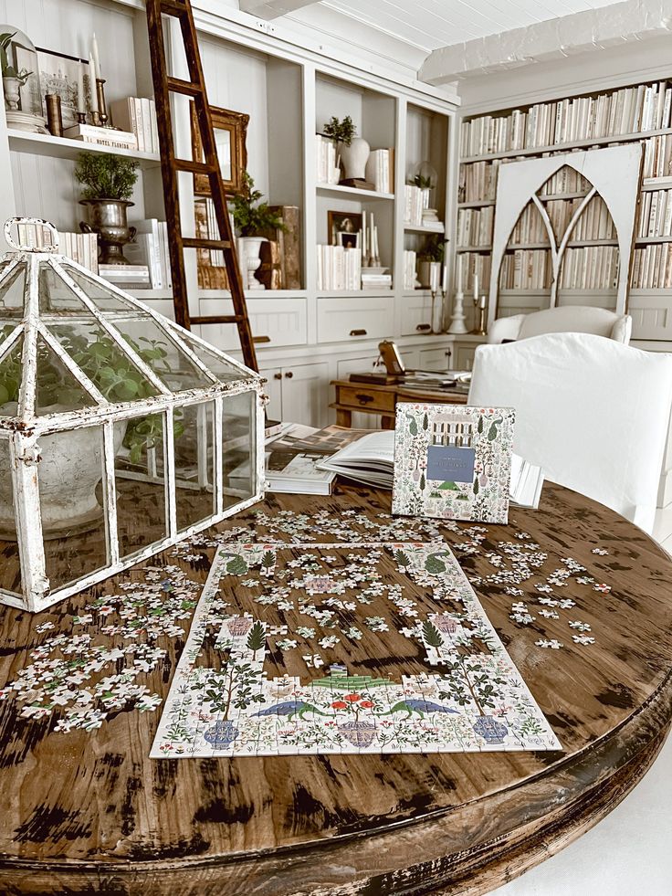 a wooden table topped with lots of pieces of puzzles next to a white couch