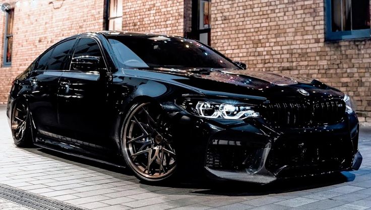 a black car parked in front of a brick building