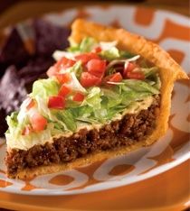 a piece of pie with lettuce and tomatoes on it sitting on a plate