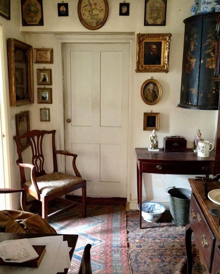 an old fashioned room with antique furniture and pictures on the wall