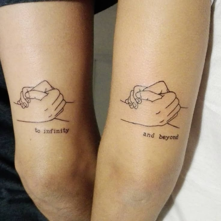 two people with tattoos on their arms holding hands and the words beyond end are written in cursive writing