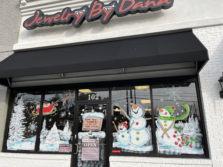 the front of a jewelry store with snowmen and christmas decorations on it's windows