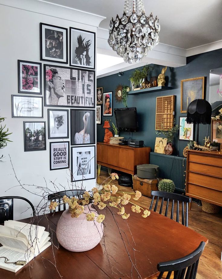 a dining room table with pictures on the wall