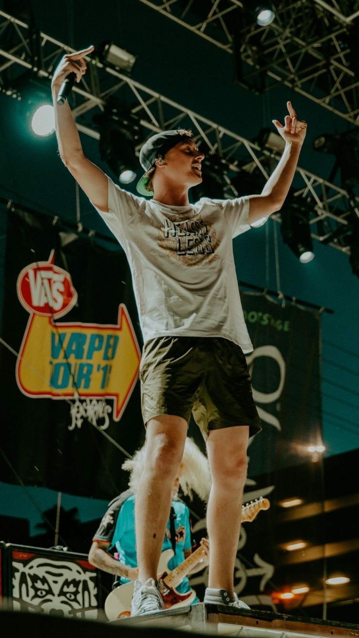 a man standing on top of a skateboard in front of a sign