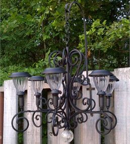 an old fashioned chandelier hanging from a wooden fence