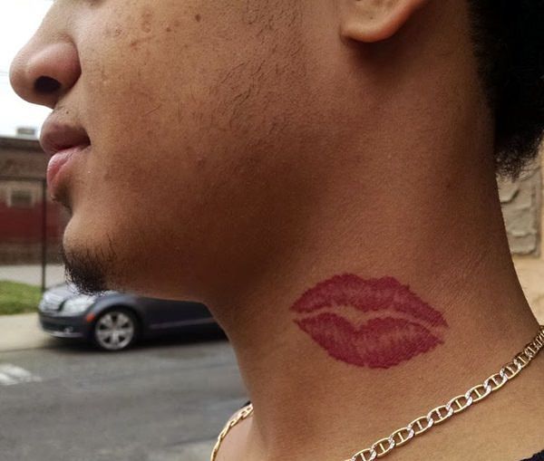 a close up of a person with a red lipstick tattoo on their neck and chest