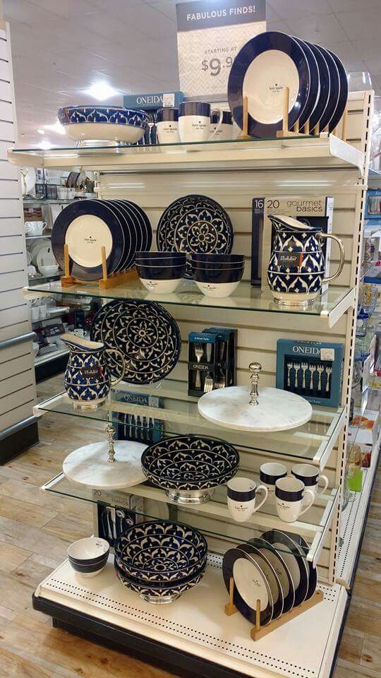 an assortment of black and white plates on display in a store with wooden flooring