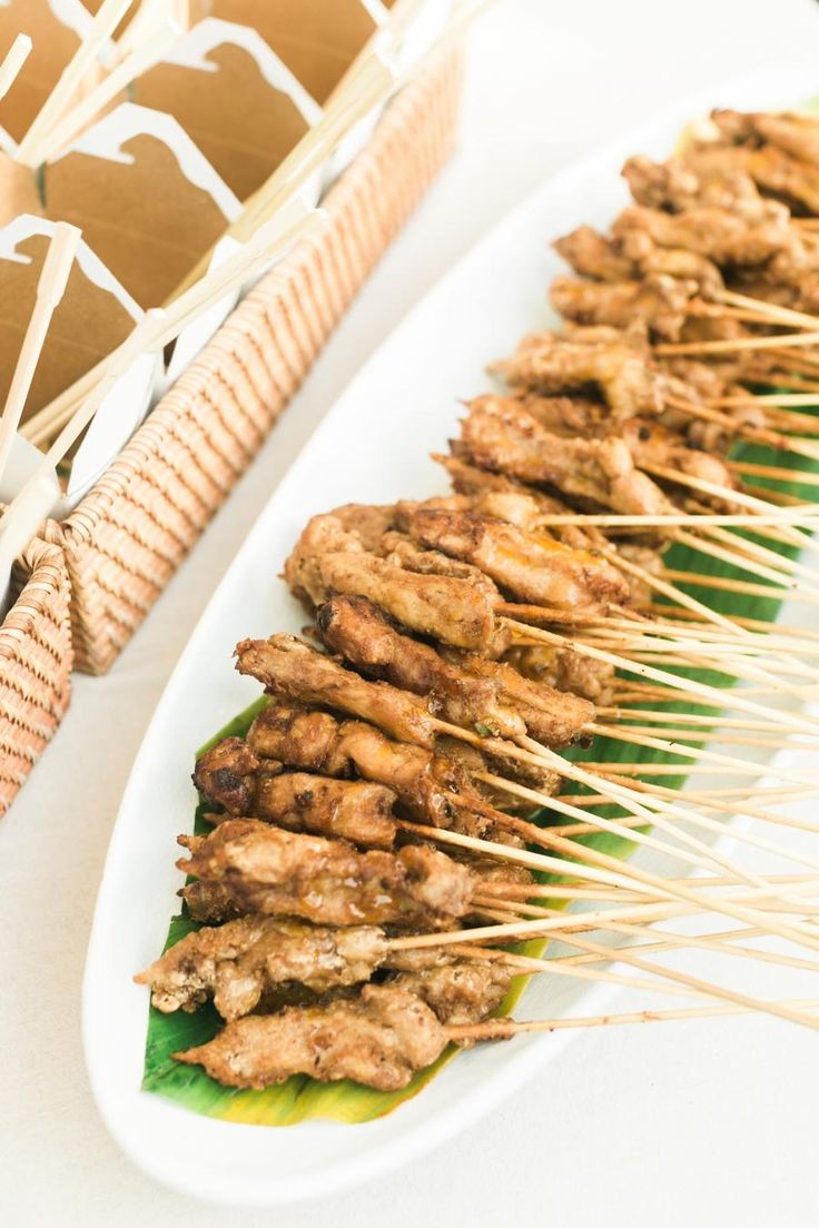 several skewers of food on a white plate