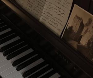 an old piano with writing on it next to a sheet of paper that has been placed on top of it