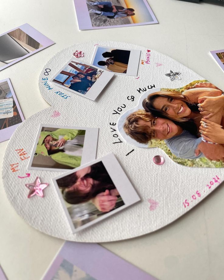 two women are hugging each other in front of pictures on a circular table with pink flowers