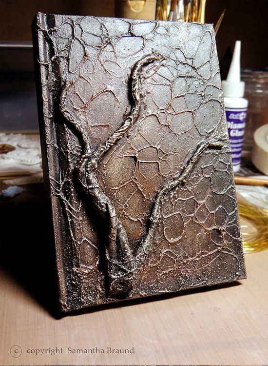 a book that is sitting on top of a wooden table with paint and brushes in it