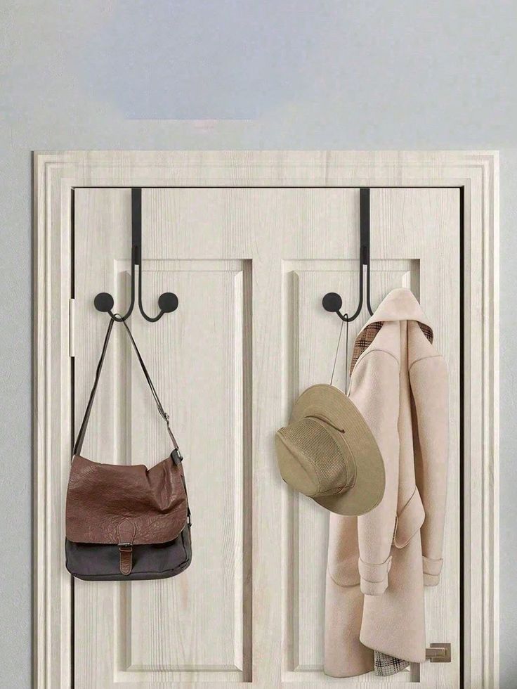 a white door with two hooks holding hats and purses