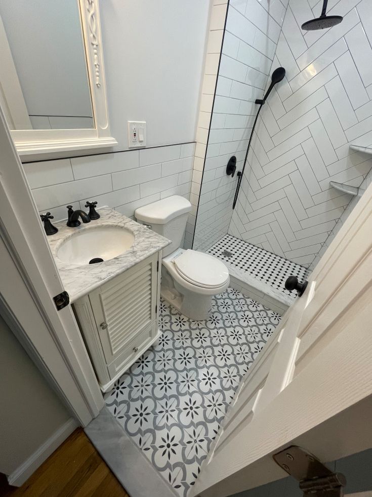 a bathroom with a toilet, sink and shower stall in it's own area