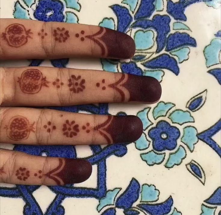 a woman's hand with henna tattoos on it