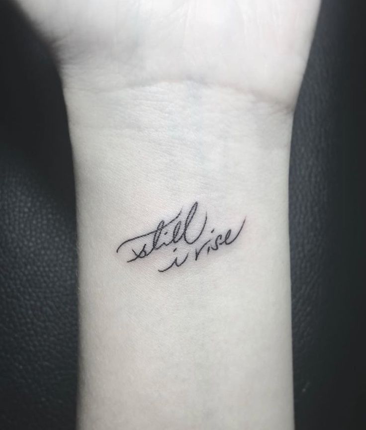 a small wrist tattoo with the words still alive on it