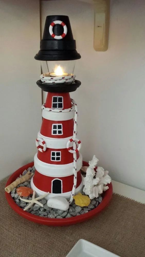 a red and white lighthouse with a black hat on top