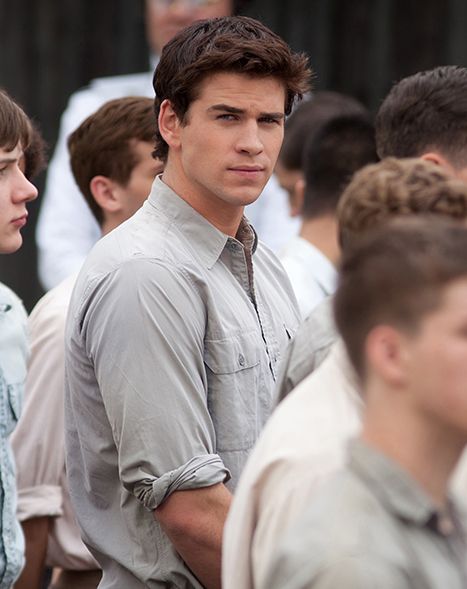 a group of young men standing next to each other in front of a crowd of people