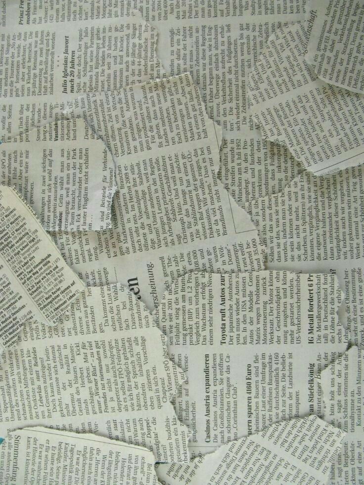 a pile of torn newspaper sitting on top of a table