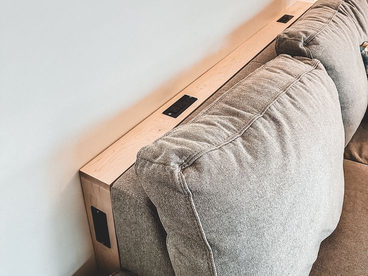 a couch that is sitting on the floor next to a wall with a remote control in it