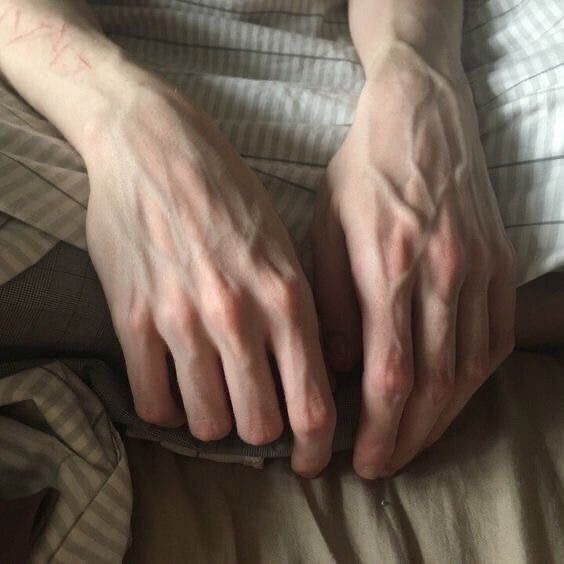 a person with their hands on the bed