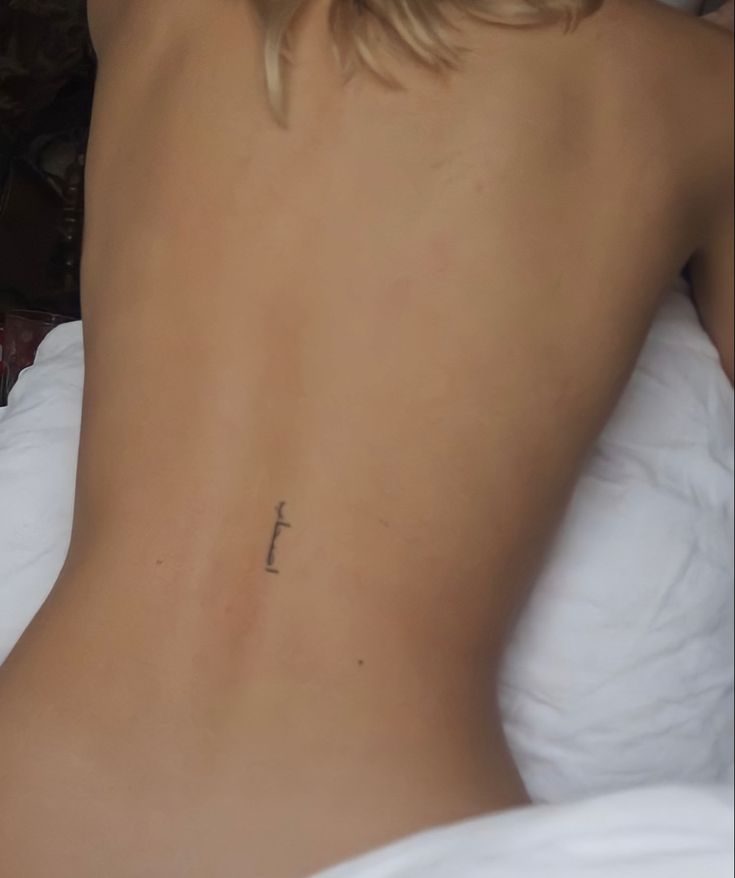 a woman with a cross tattoo on her back