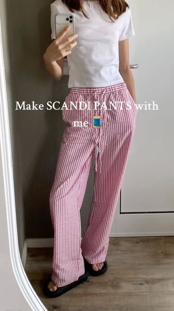 a woman taking a selfie with her cell phone wearing pink and white striped pants