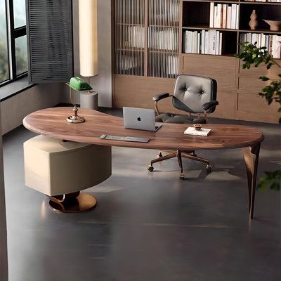 an office desk with a laptop on it in front of a bookcase filled with books