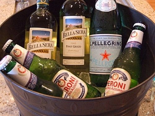 a bucket filled with lots of different types of beer bottles on top of a counter