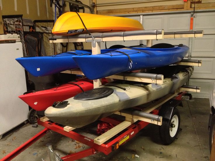 several kayaks are stacked up in a garage