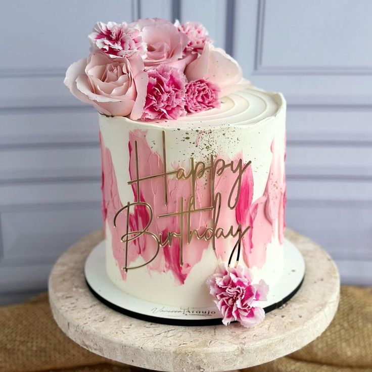 a birthday cake with pink flowers on top