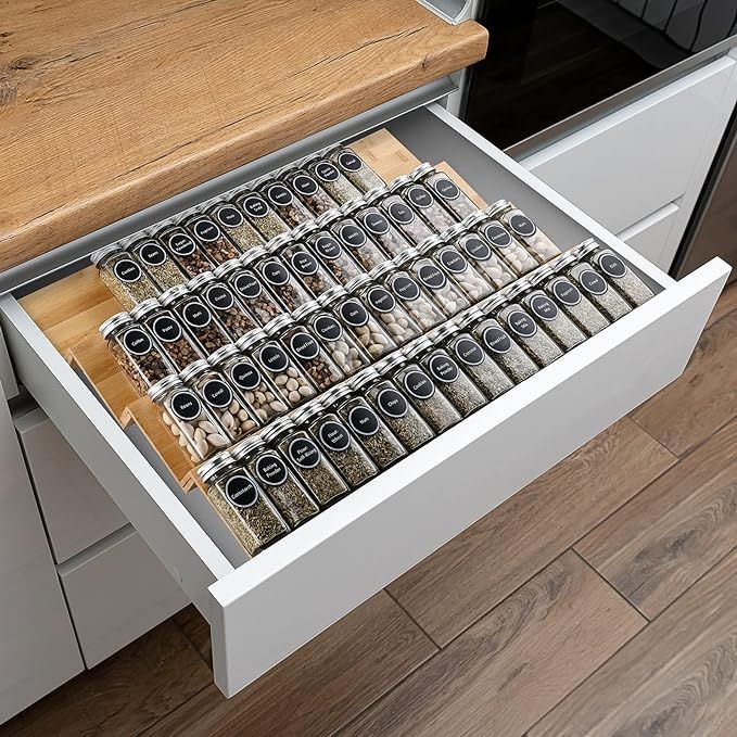 an open drawer in a kitchen filled with spices