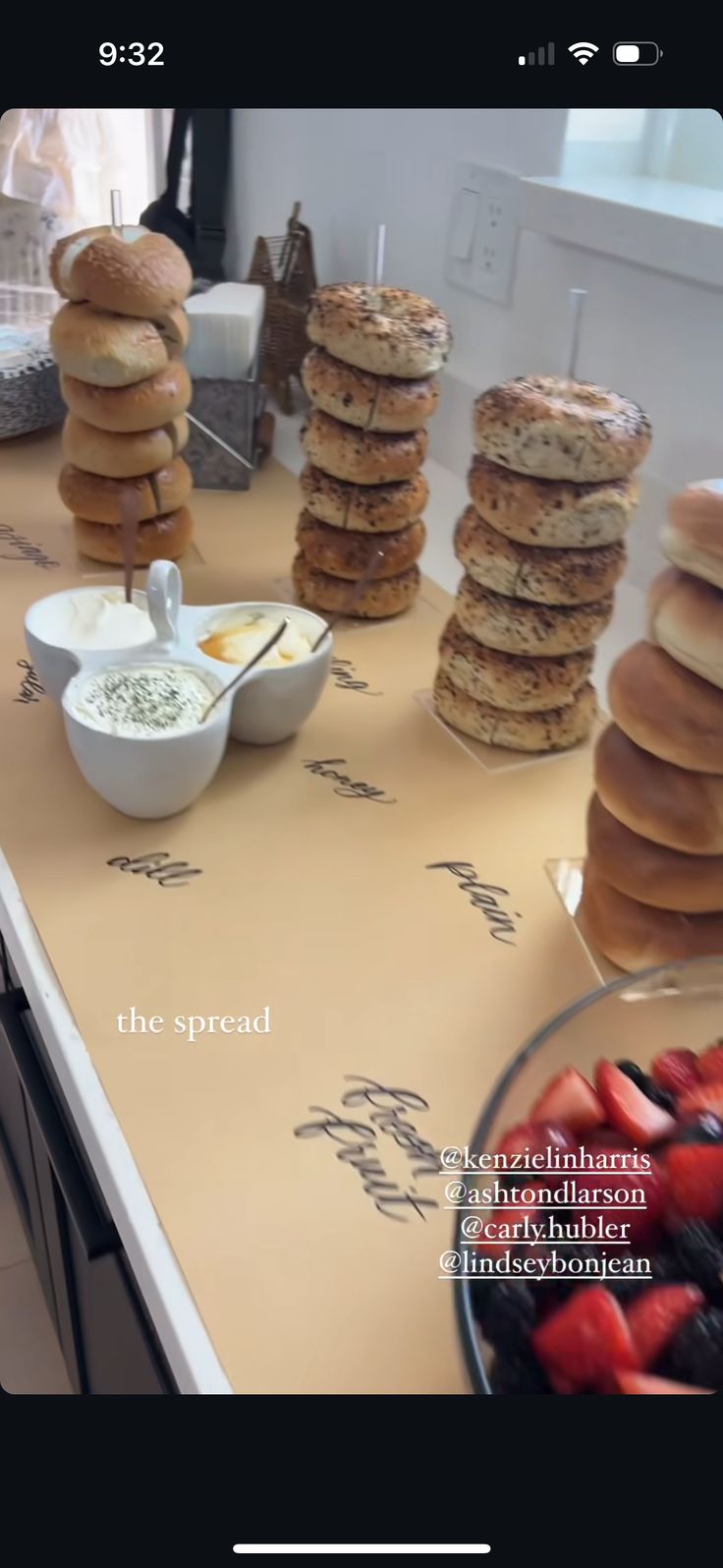 a table topped with lots of donuts next to bowls of strawberries and other foods