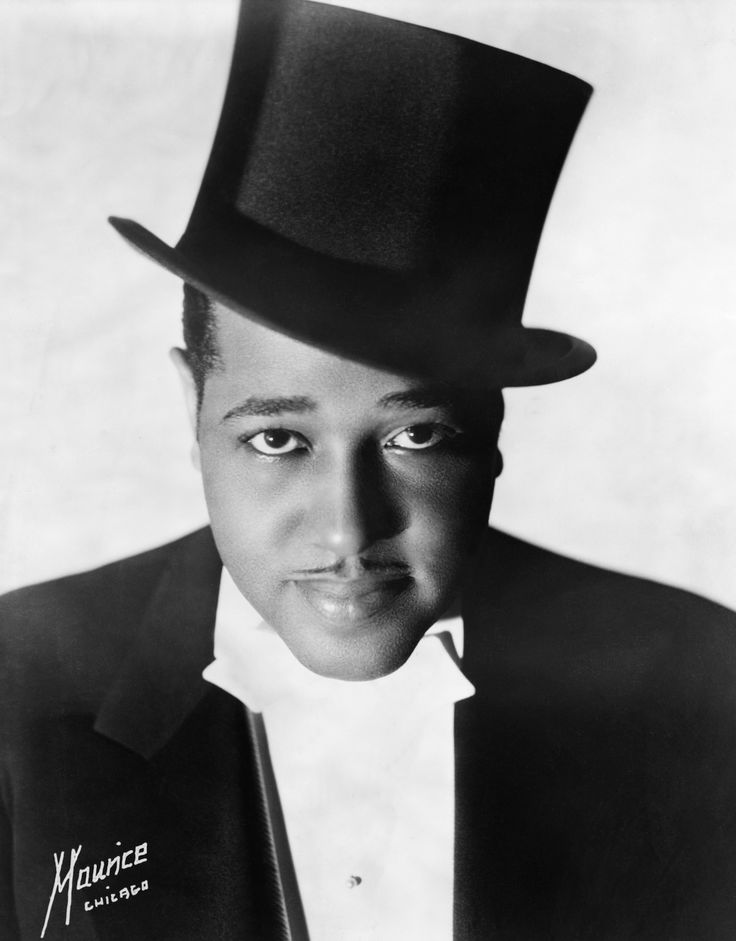 a black and white photo of a man wearing a top hat