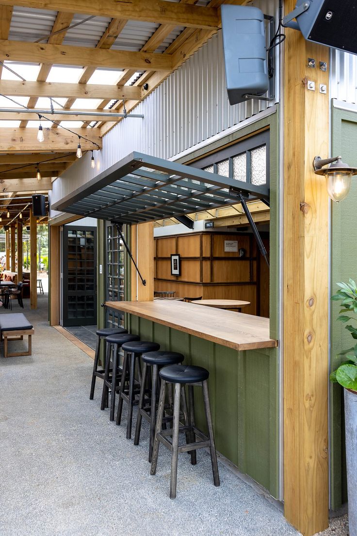 an outdoor bar with stools and barstools in front of the counter area