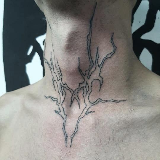 a man's neck is adorned with an intricate tree branch tattoo on his left side